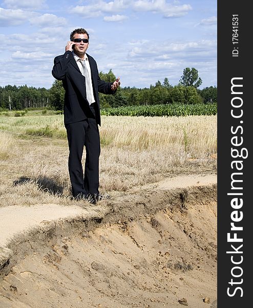 A businessman dressed in a smart suit standing on grass