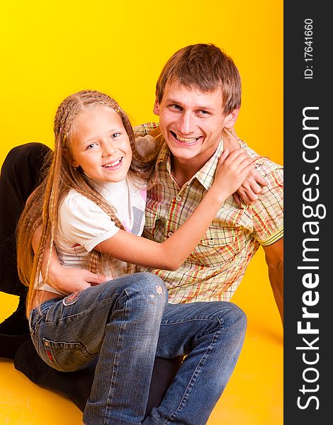 Happy dad with daughter on a yellow background