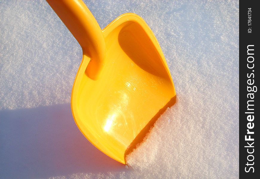 Children's shovel of yellow color in snow. Children's shovel of yellow color in snow.