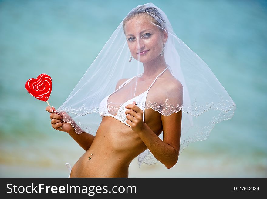 Beautiful girl holding a lollipop on the beach. Beautiful girl holding a lollipop on the beach