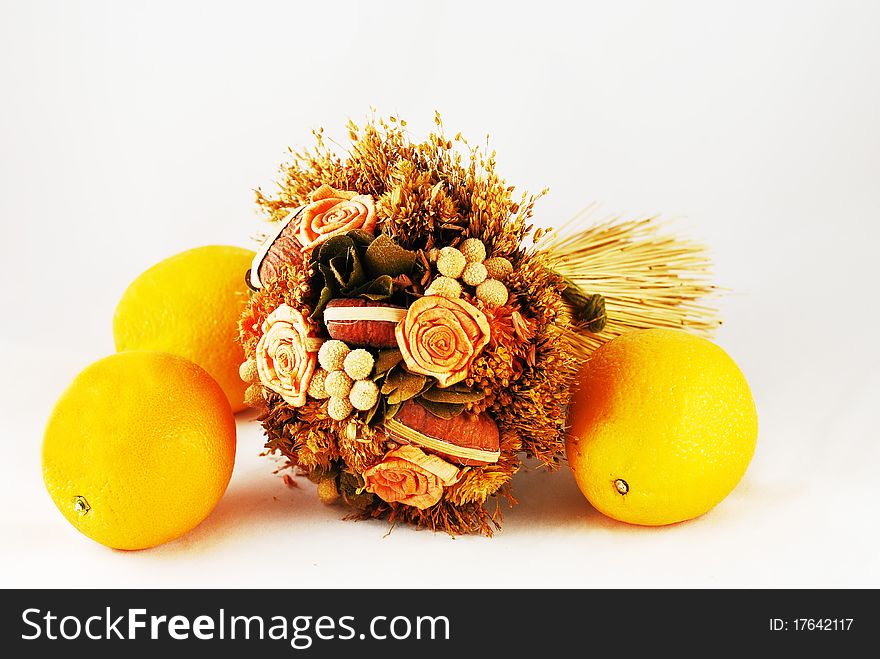 A bouquet of dried flowers and three oranges. A bouquet of dried flowers and three oranges