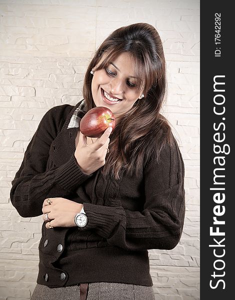 Beautiful girl holding red apple in her hand and smiling. Beautiful girl holding red apple in her hand and smiling.
