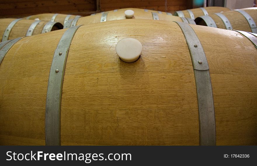 Wine barrels line up with wine
