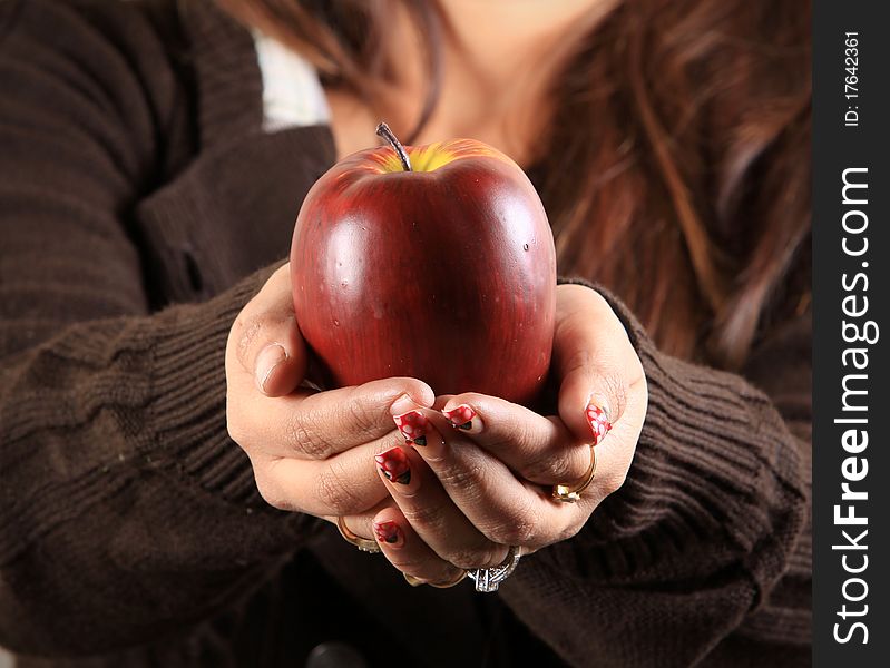 Female hands holding ripe red apple. Female hands holding ripe red apple.