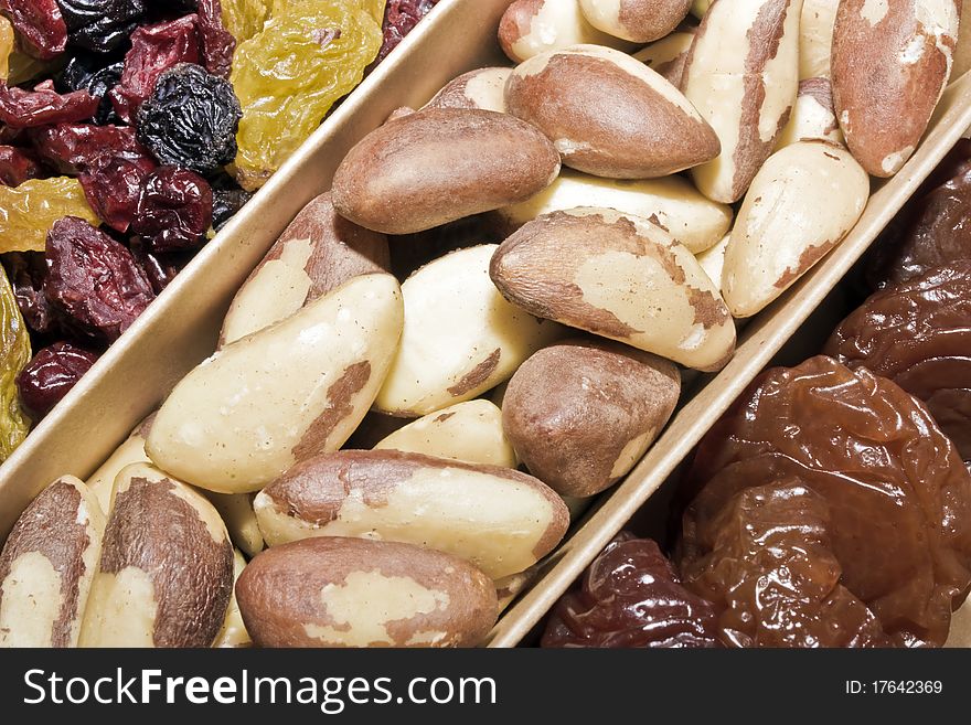 A close up of a box of dried fruit and brazil nuts. A close up of a box of dried fruit and brazil nuts