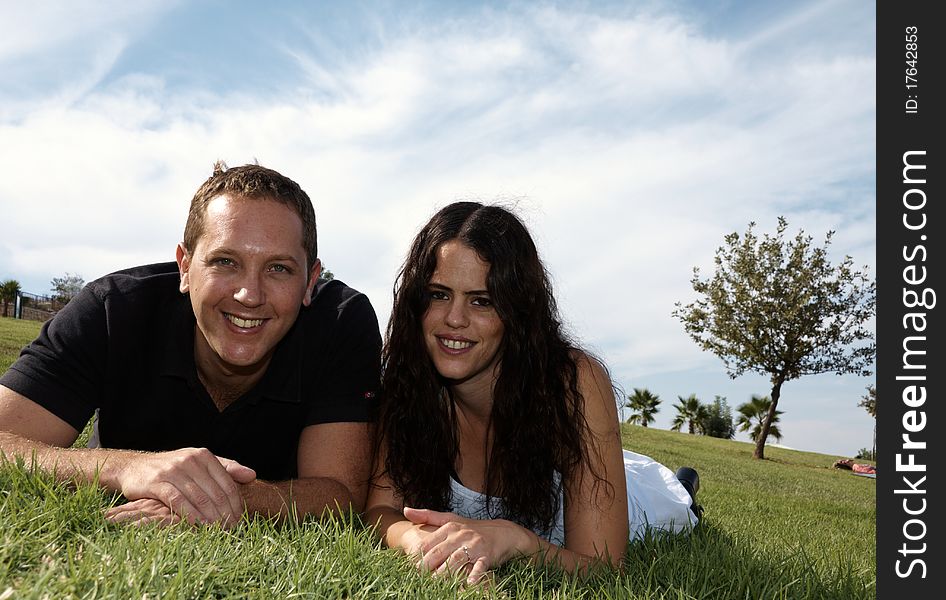 Happy young couple lying on the grass