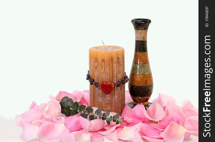 Candle and vase with rose petals and heart beads; on white background. Candle and vase with rose petals and heart beads; on white background.