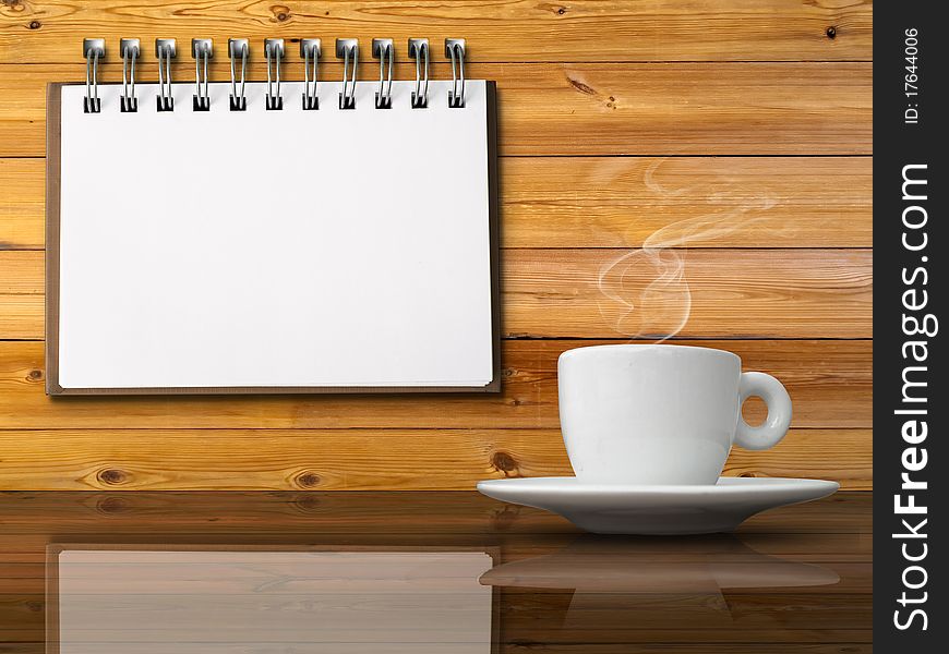White cup of hot coffee on table and White note paper on wood wall. White cup of hot coffee on table and White note paper on wood wall