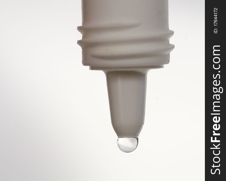 Eyedropper dropping water drop on white background