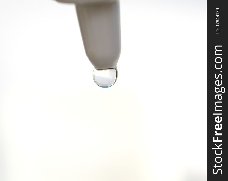 Eyedropper dropping water drop on white background