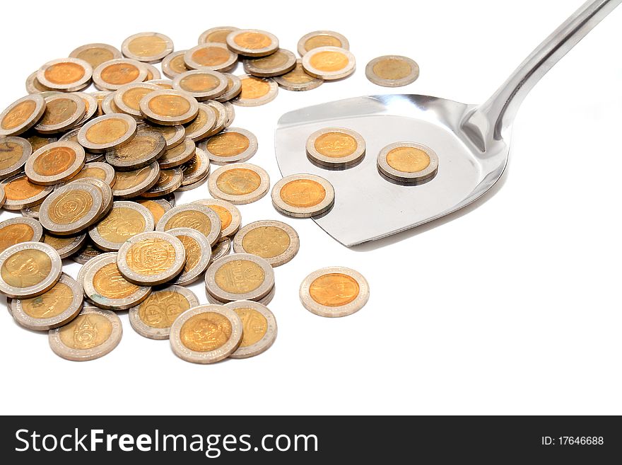 Coins and the spoon in a plate on a white background