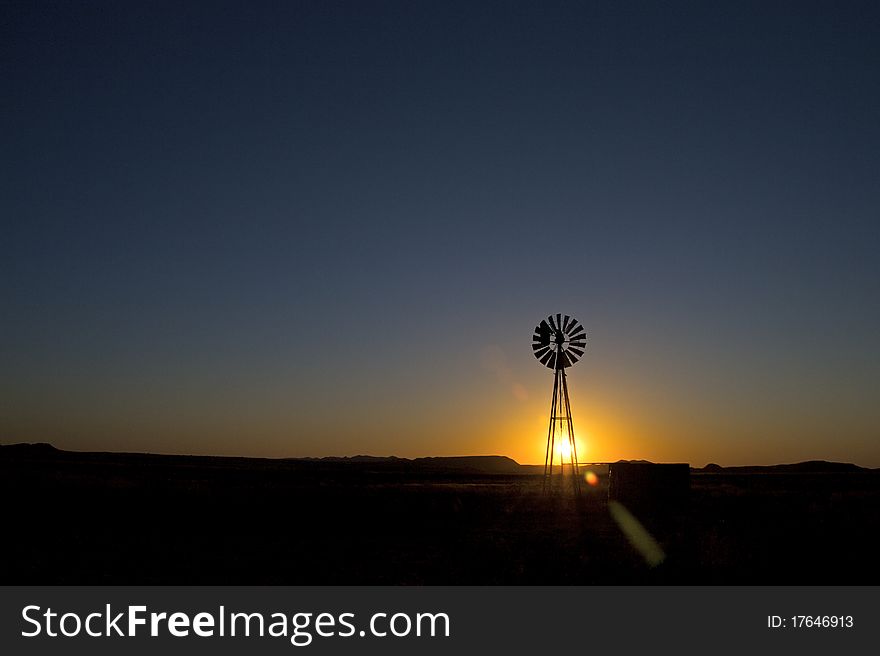 Windmill at sunset in clearing. Windmill at sunset in clearing