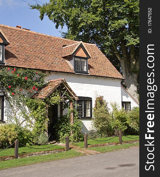 Traditional whitewashed English Village Cottage  with roses on the wall. Traditional whitewashed English Village Cottage  with roses on the wall