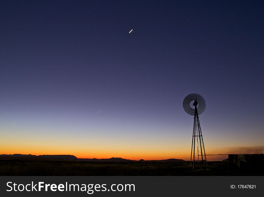 Windmill at sunset in clearing. Windmill at sunset in clearing