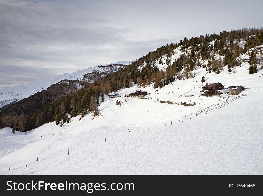 Cabins in a mountain valley in the North of Italy during winter. Brixia province, Lombardy region, Italy. Cabins in a mountain valley in the North of Italy during winter. Brixia province, Lombardy region, Italy
