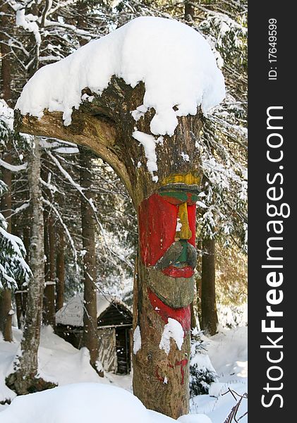 Handmade carved coloured totem in snow.