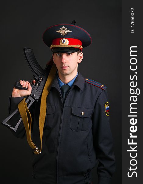 Police officer in uniform with machine gun AK-47