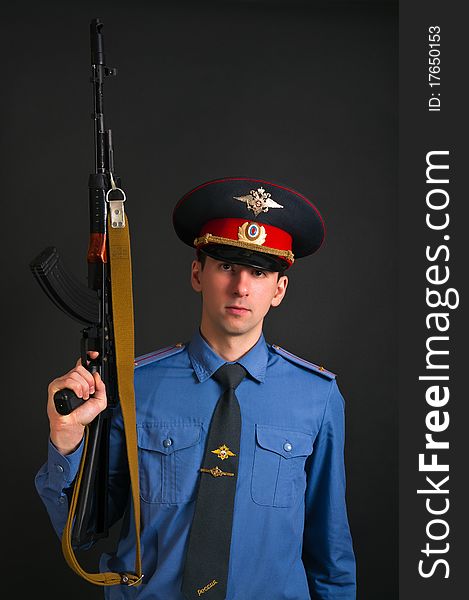 Police officer in uniform with machine gun AK-47