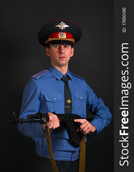 Police officer in uniform with machine gun AK-47