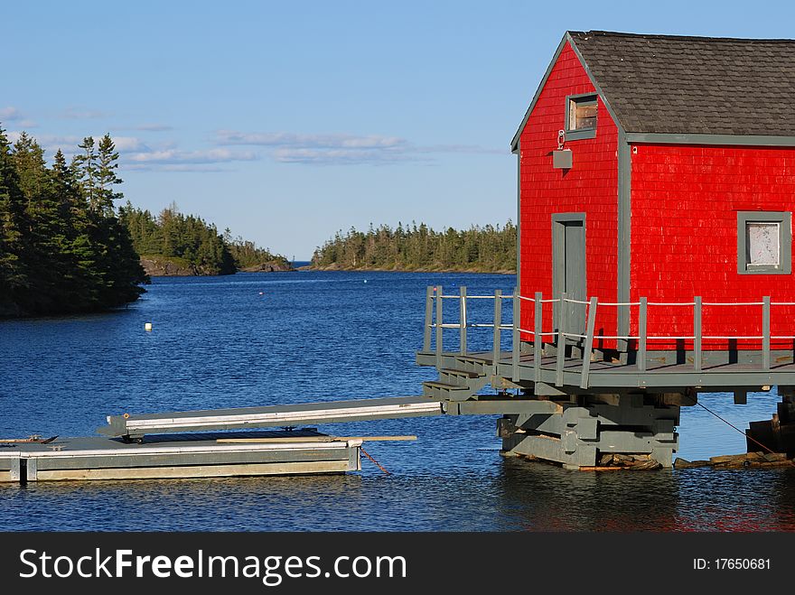 A red building is sits near the water. A red building is sits near the water