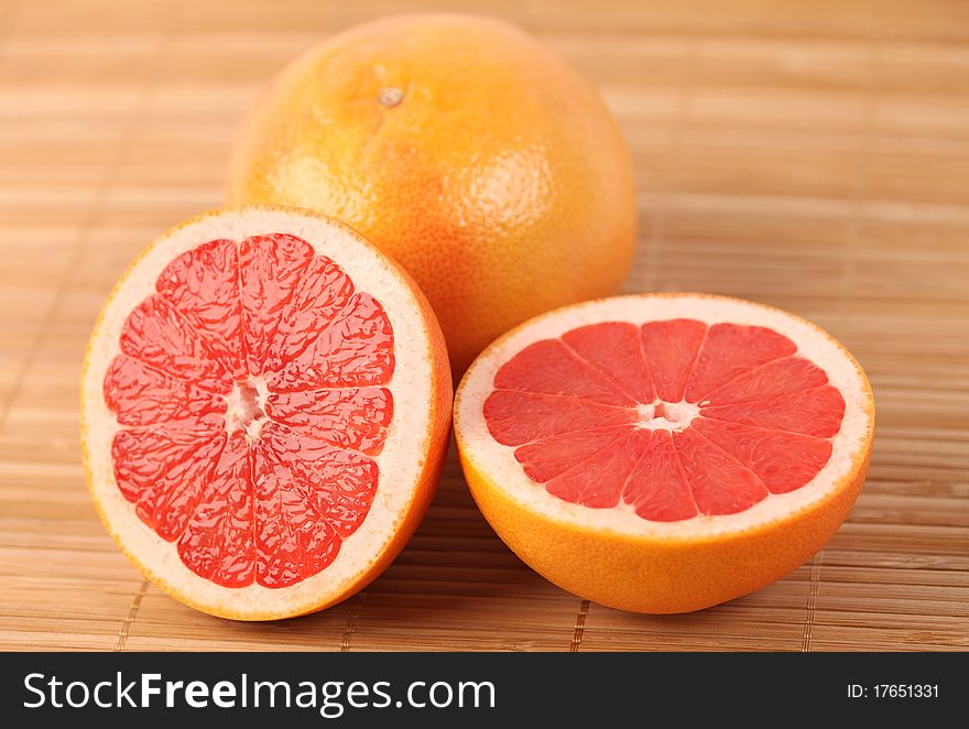 Two red juicy grapefruits on wooden carpet. Two red juicy grapefruits on wooden carpet