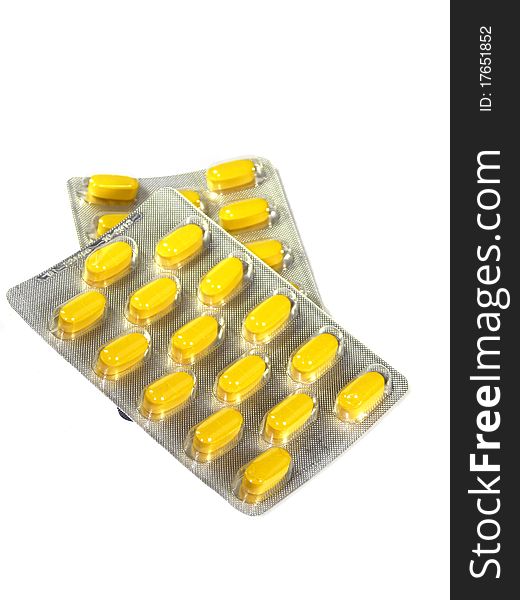 Yellow pills in blister isolated on a white background