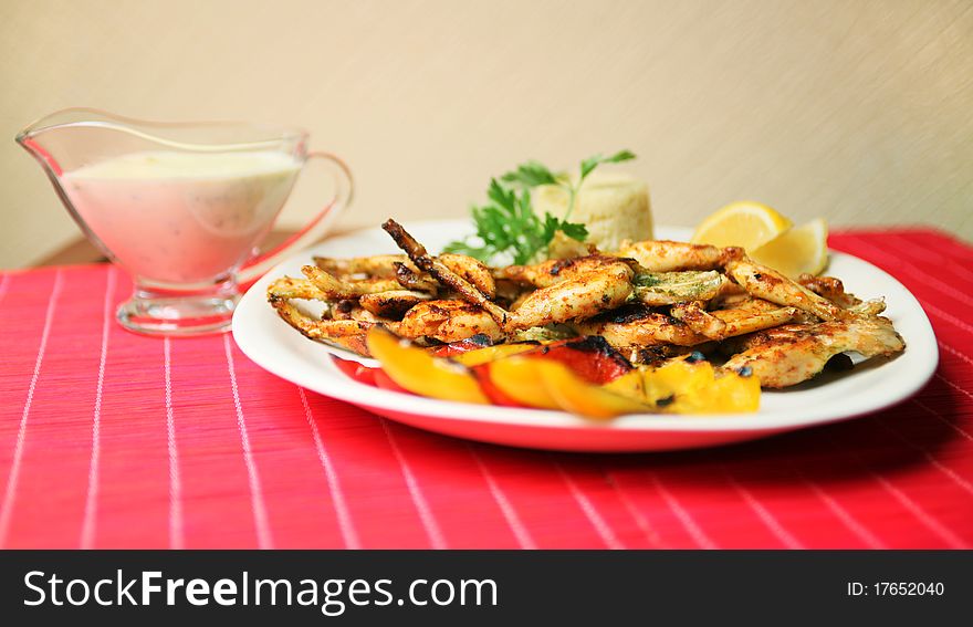 Frog legs with couscous and fried pepper (shallow DOF)