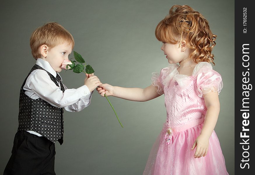 The little boy gives to the girl a flower. The little boy gives to the girl a flower