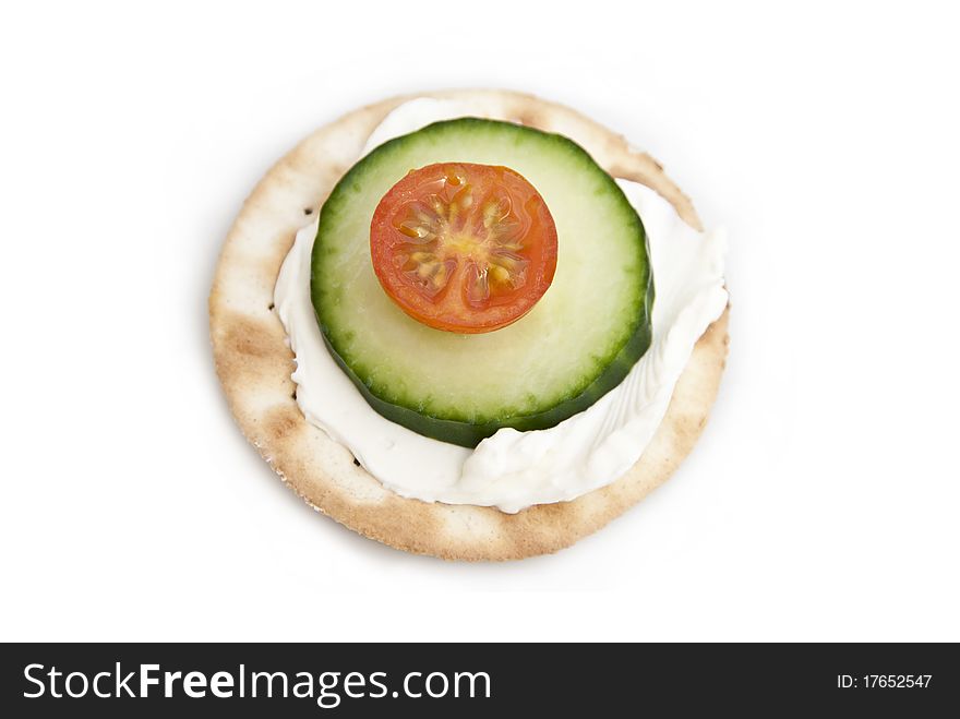 Cream cheese on a cracker with tomato and cucumber. Cream cheese on a cracker with tomato and cucumber