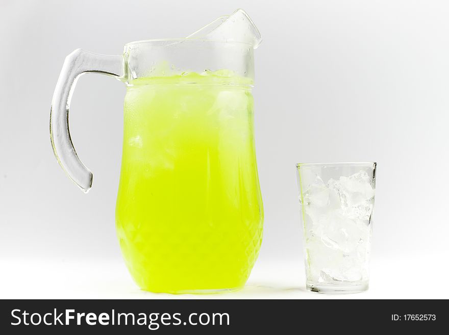 Lime flavoured cold drink in a glass jug next to a glass of ice. Lime flavoured cold drink in a glass jug next to a glass of ice