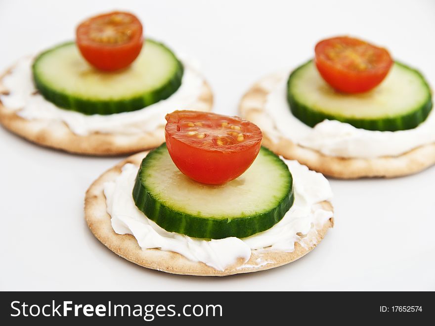 Cream cheese on a crackers with tomato and cucumber. Cream cheese on a crackers with tomato and cucumber