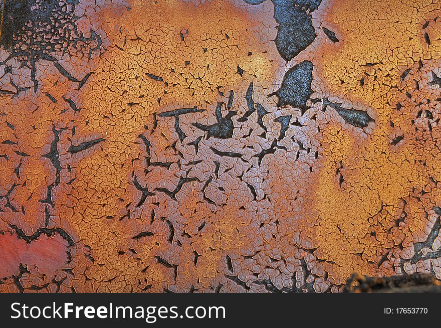Old Metal surface with peeling paint in orange tones