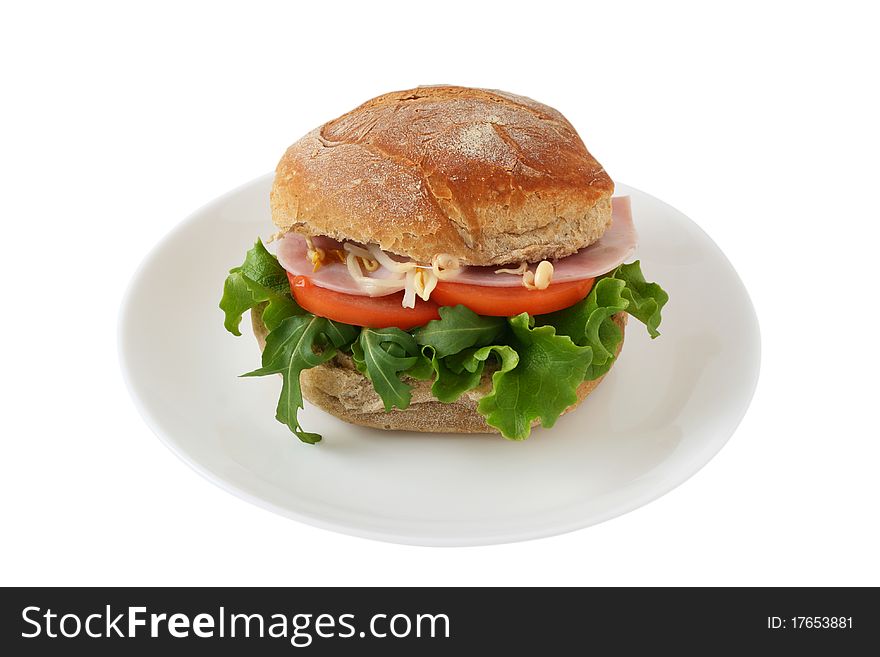 Sandwich with ham, salad and tomato on a plate