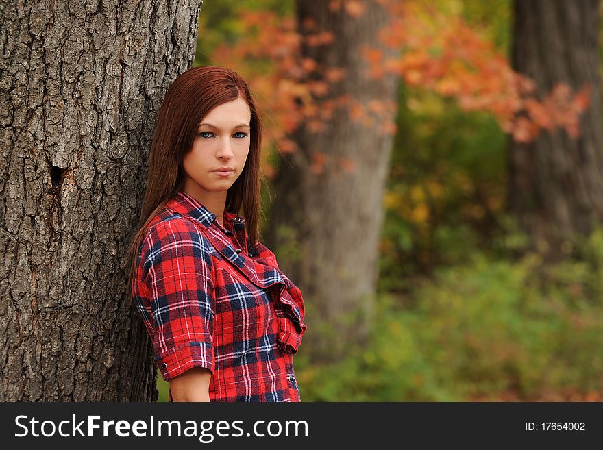 Young Woman standing by a tree