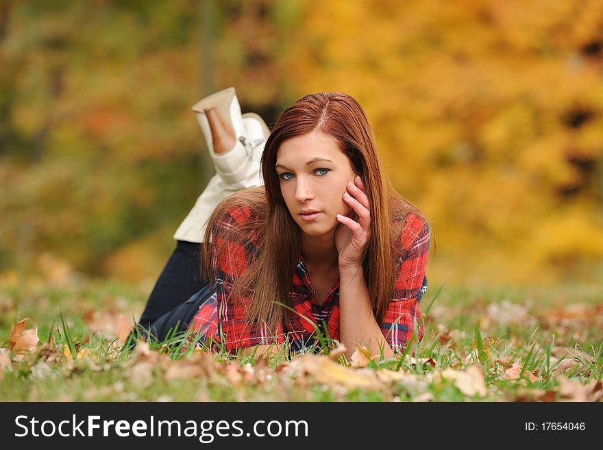 Young Woman laying down at a park during fall season