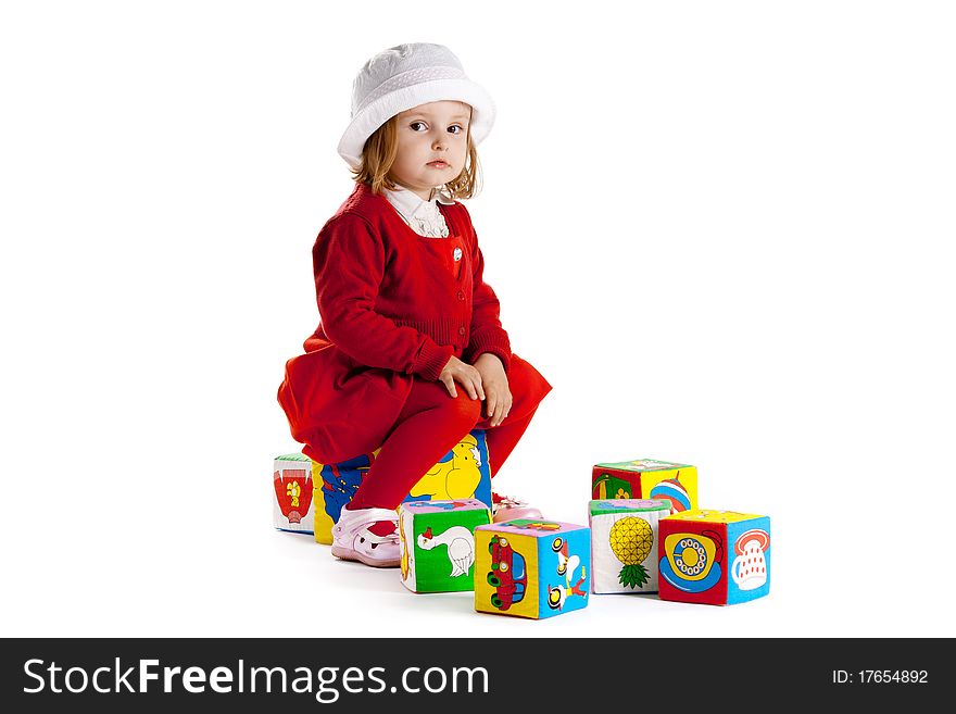 Little girl sitting on cubes isolated