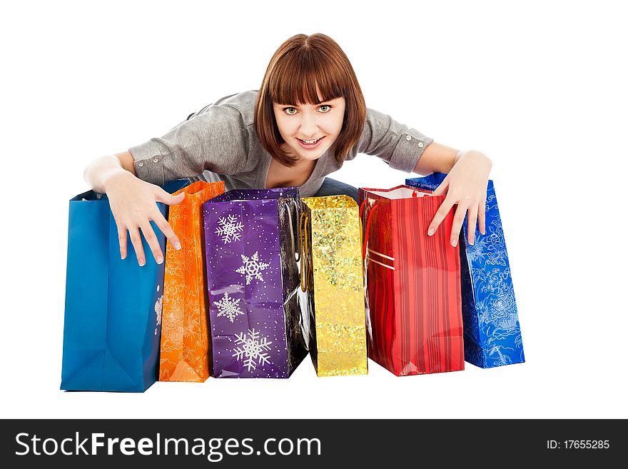 Young smiling woman with colored shopping bags, isolated on white