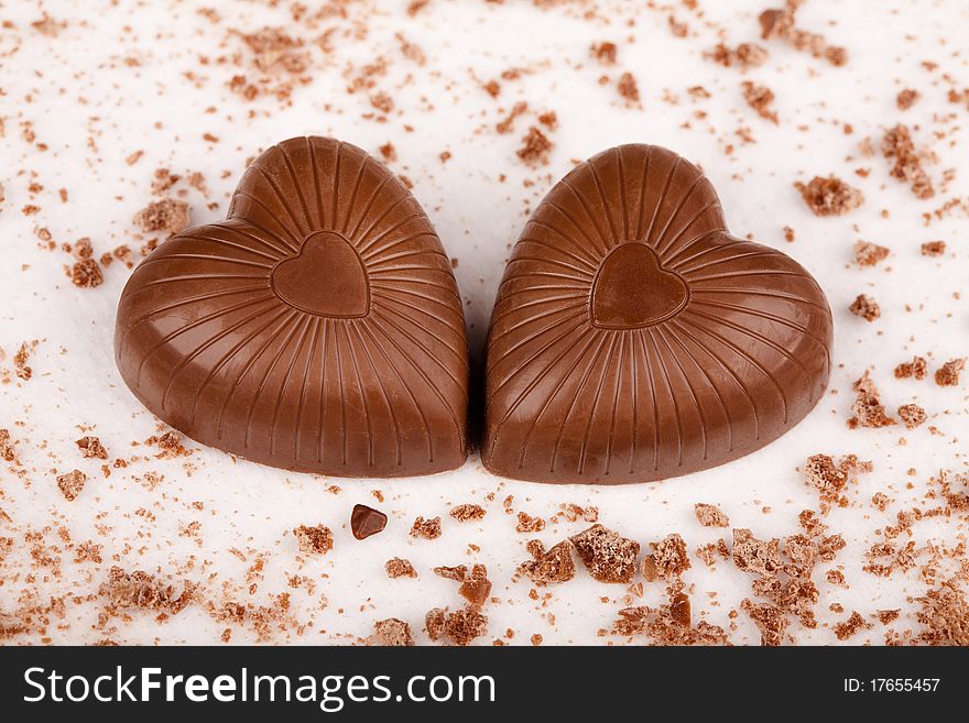 Two chocolate hearts with crumbs on white background