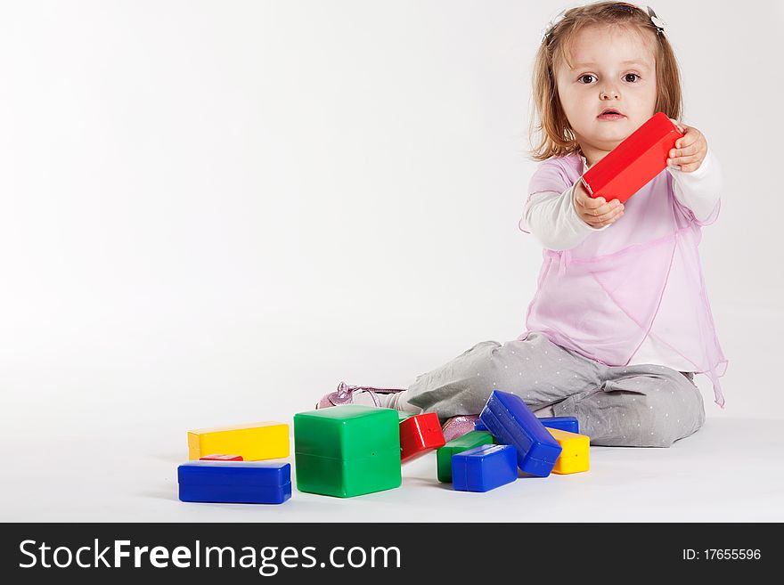 Little girl plays with cubes