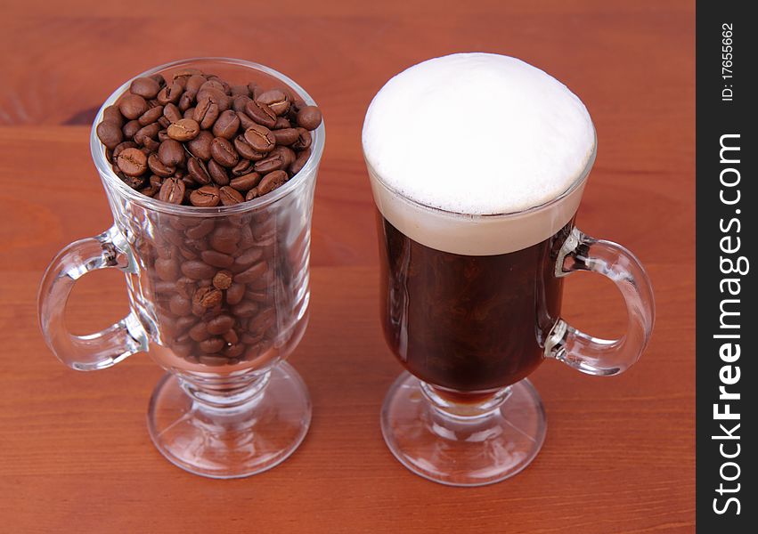 Glass of caffe latte with a glass of coffee beans on white background. Glass of caffe latte with a glass of coffee beans on white background