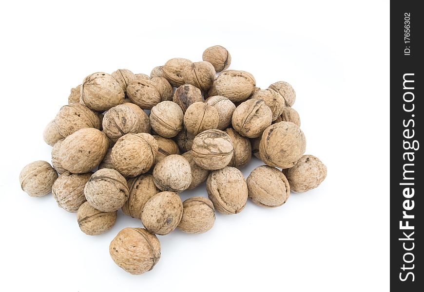Heap of mature and dry walnuts on a white background. Heap of mature and dry walnuts on a white background