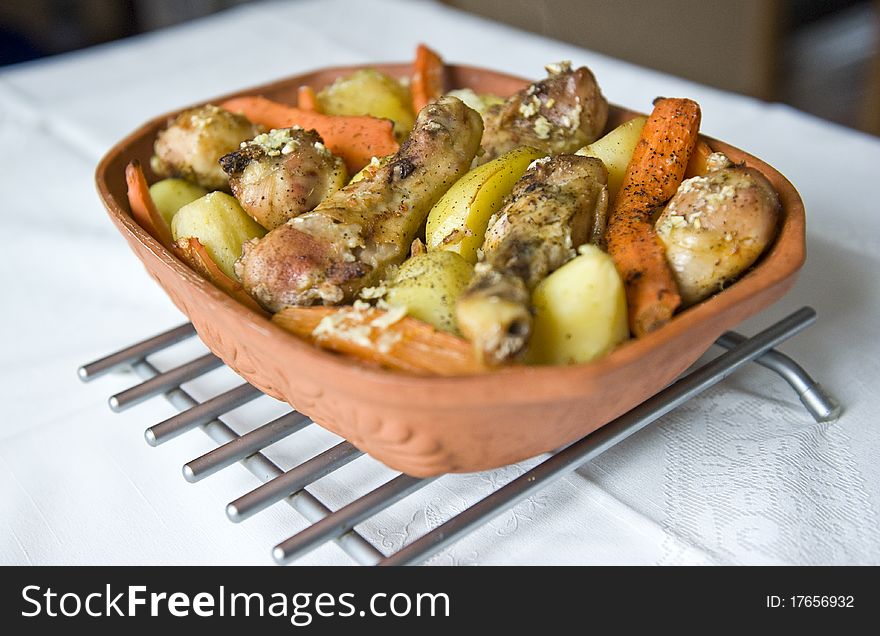 Roasted chicken and potatoes on a pot