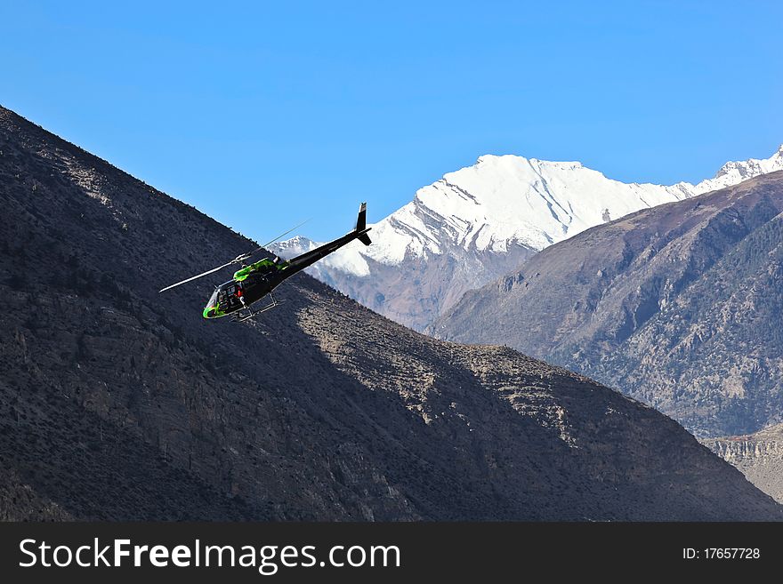 Black helicopter over Annapurna range