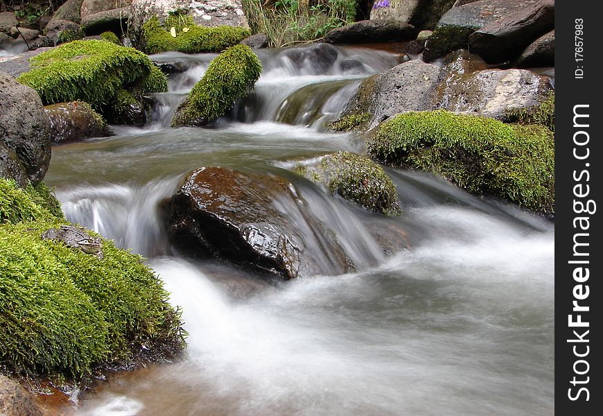 A mountain river with stream falling into it.