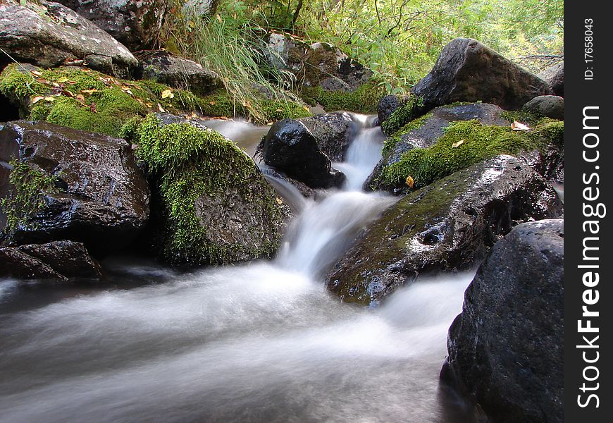 A mountain river with stream falling into it.