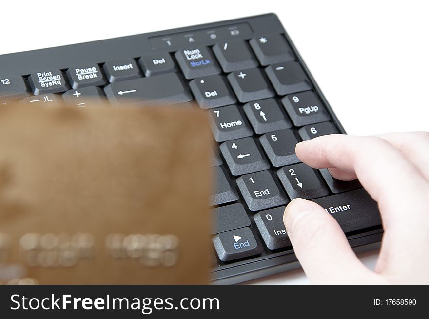 HANDS HOLDING CREDIT CARD ON KEYBOARD