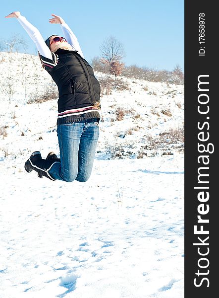 Young woman jumping of joy in a winter setting