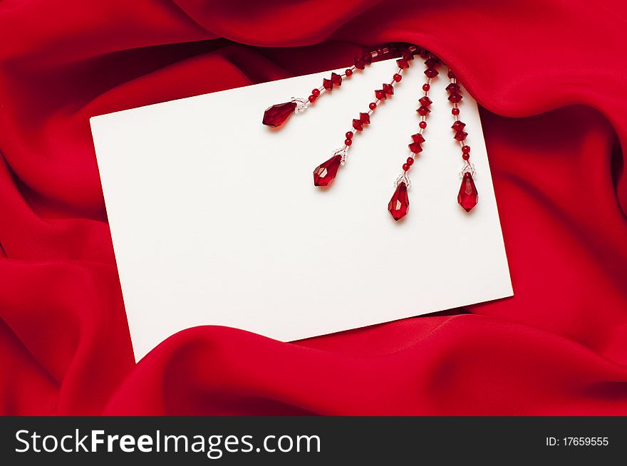 Empty greeting card on red satin background. Empty greeting card on red satin background