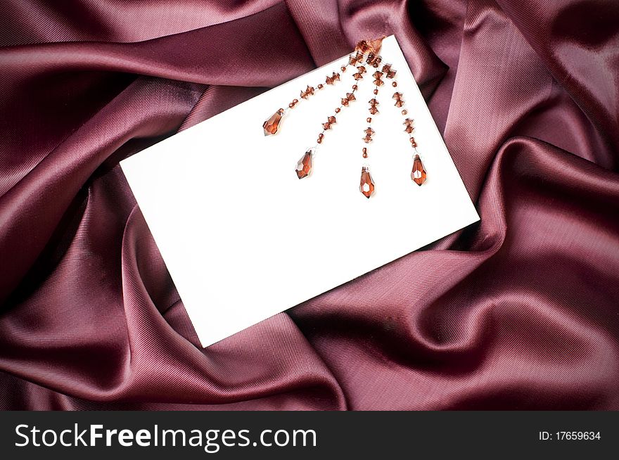 Empty greeting card on ruby satin background. Empty greeting card on ruby satin background