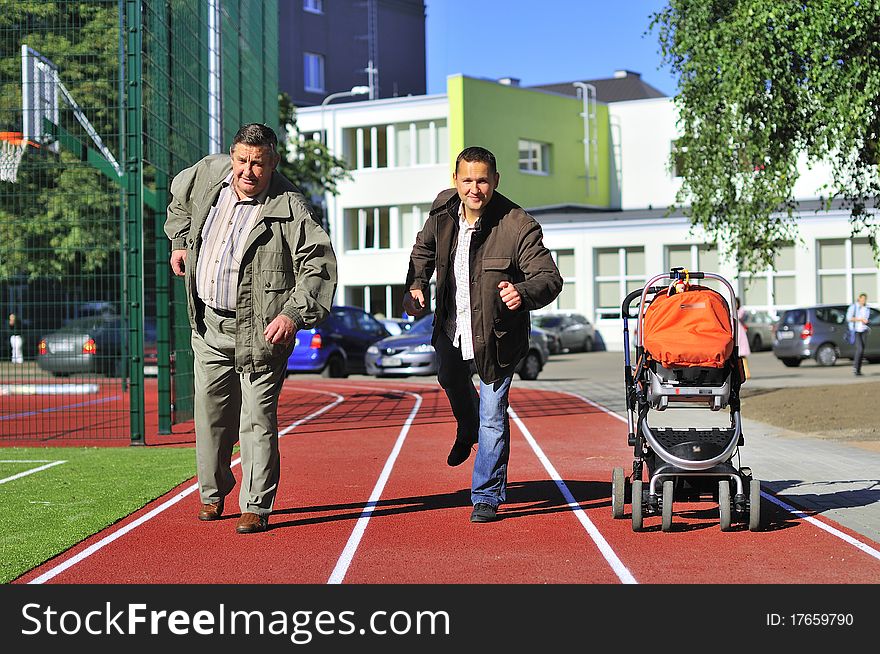 Father, son and grandson running on the running track. Father, son and grandson running on the running track.